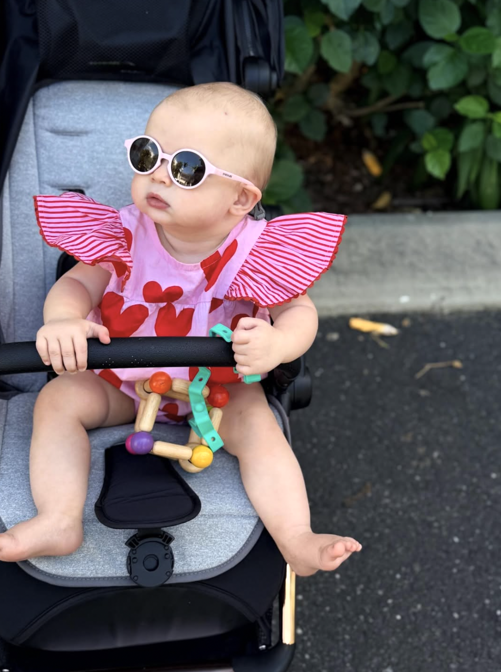 Baby in stroller with Busy Baby toy tether